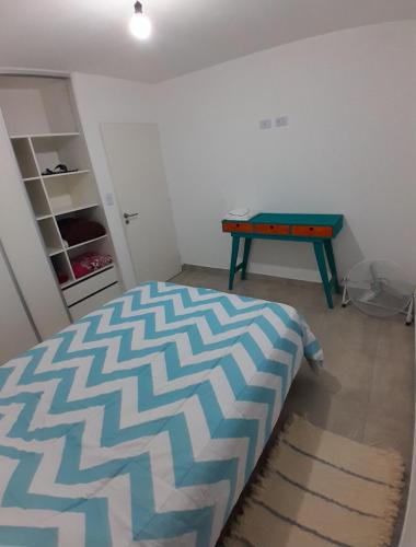 Un dormitorio con una cama y una mesa dentro. en Departamento ÚNICO, en Presidencia Roque Sáenz Peña