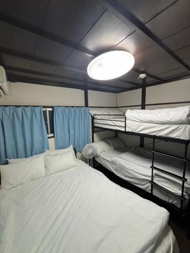 a room with two bunk beds and a light at ワカバハウス in Wada