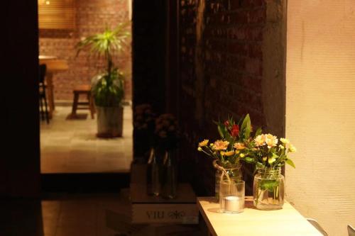 a table with two vases with flowers on it at Beijing MutianyuGreat Wall Let'sgo Hotel&Bar in Huairou
