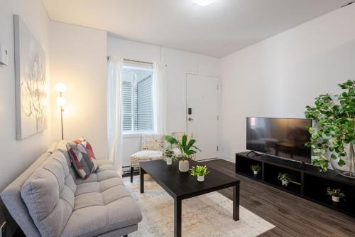 a living room with a couch and a tv at Luxurious 4 BR Suite in Griffintown in Montréal