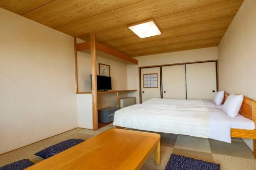 a bedroom with a white bed and a wooden ceiling at YU-FURI Nasu-Takao Onsen Lodge in Nasu