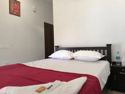 a bed with white sheets and pillows on it at Sea Breeze Cherai Homestay in Pallipuram