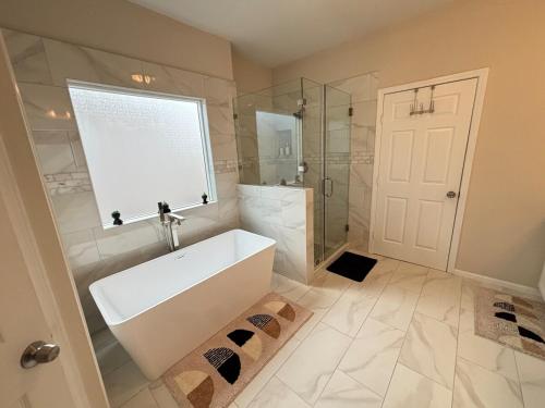 a bathroom with a white tub and a shower at Three Bedroom ClubHaus in Houston