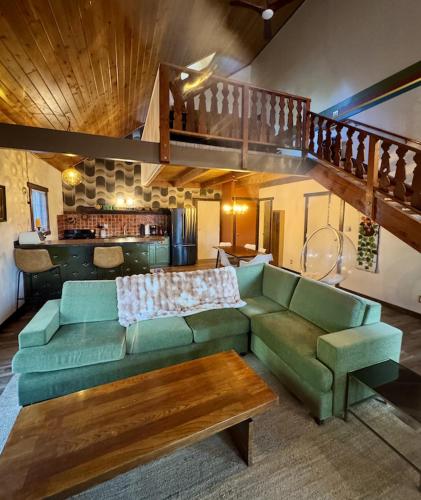 a living room with a green couch and a table at Black Forest Lodge in Big Bear Lake