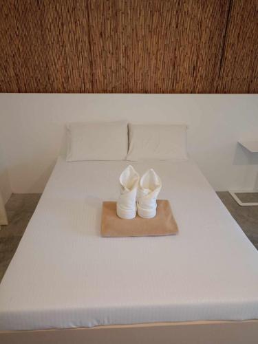 a pair of white shoes sitting on a bed at OCEAN 9 siargao in General Luna