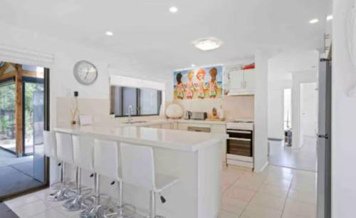 a white kitchen with a large white counter top at Beach House Getaway 2 in Smiths Beach