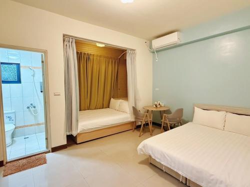 a bedroom with a bed and a bathroom with a shower at 時光旅舍 in Jincheng