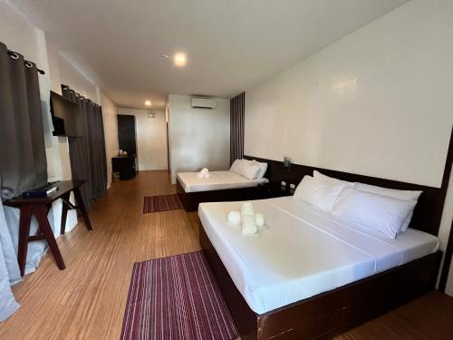 a hotel room with a large bed and a desk at The Ananyana Beach Resort by SMS Hospitality in Panglao