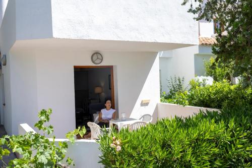 a woman sitting at a table outside of a house at Villa Turística de Laujar de Andarax in Laujar de Andarax