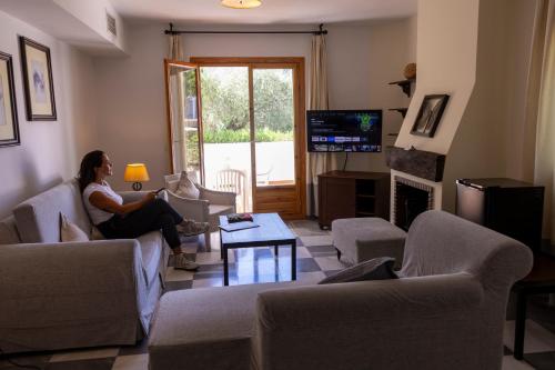 a woman sitting in a living room watching tv at Villa Turística de Laujar de Andarax in Laujar de Andarax