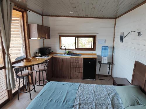 a small kitchen with a bed in a small room at Posada Vista Hermosa Colibri in Lo Narváez