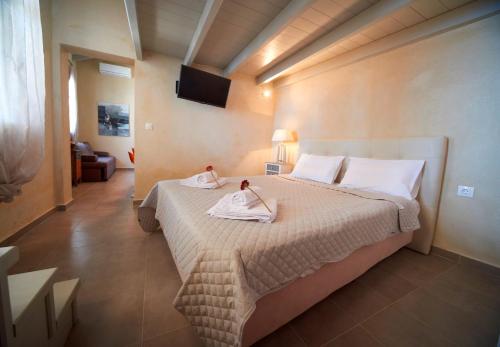 a bedroom with a bed with two towels on it at Villa Aktaia in Keramídhion