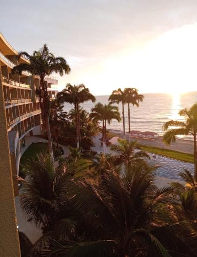 a view of a resort with palm trees and the ocean at MAKANA Tonsupa - Suites y Departamentos Familiares - Deluxe Suites in Tonsupa