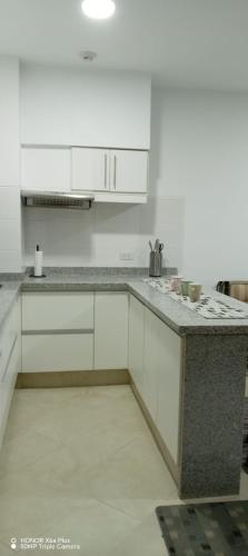 a kitchen with white cabinets and a granite counter top at MAKANA Tonsupa - Suites y Departamentos Familiares - Deluxe Suites in Tonsupa
