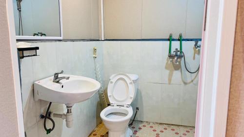a bathroom with a toilet and a sink at Sunshine Resort Hotel Coconut Beach Koh Rong in Phumĭ Kaôh Rŏng