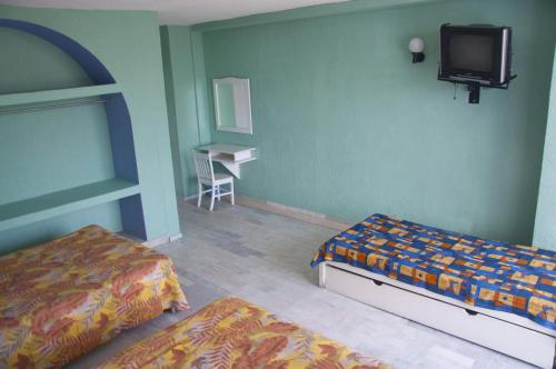 Giường trong phòng chung tại Dorados Acapulco