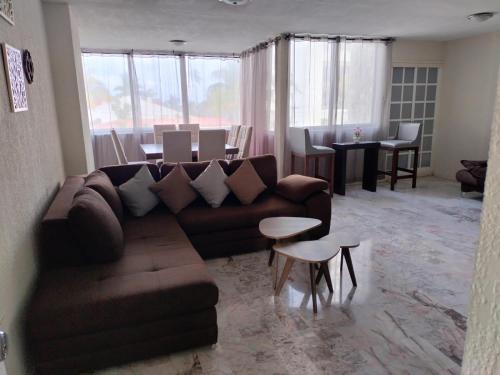 マサトランにあるAmplio Condominio Ibis Mazatlán Zona doradaのソファとテーブルのあるリビングルーム