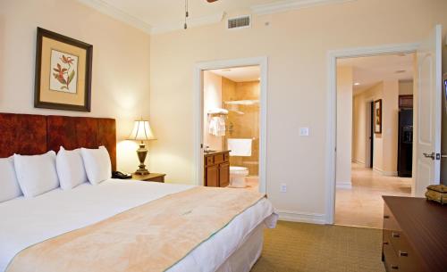 1 Schlafzimmer mit einem großen Bett und einem Badezimmer in der Unterkunft Emerald Greens Condo Resort in Tampa