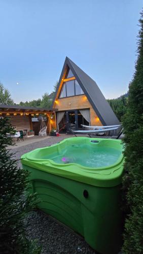 a house with a green boat in front of it at Tana dell Lupo in Colibiţa