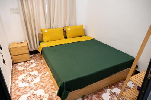 a bedroom with a bed with yellow and green sheets at SeaSpace Homestay in Phú Hiệp