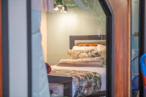 a reflection of a bedroom with a bed in a mirror at Aloki Tsalu 1 Tu refugio entre la selva y el mar in Punta Uva