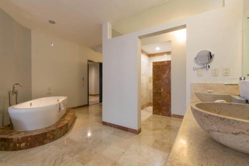 a large bathroom with two sinks and a tub at Real de Minas Poliforum in León