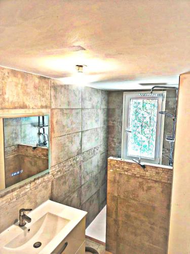 une salle de bain avec un lavabo et une fenêtre dans l'établissement -Belle vue-Villa duplex-AC-jardin-parking, à Alignan-du-Vent