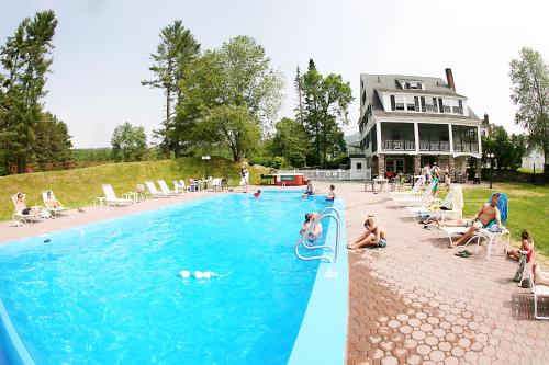 a pool with people playing in the water at Franconia Inn in Franconia
