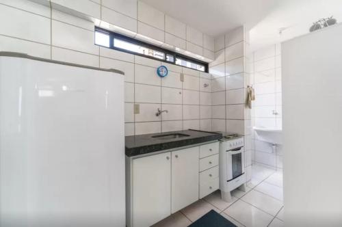 cocina de azulejos blancos con fregadero y fogones en Apartamento Em Boa Viagem!, en Recife