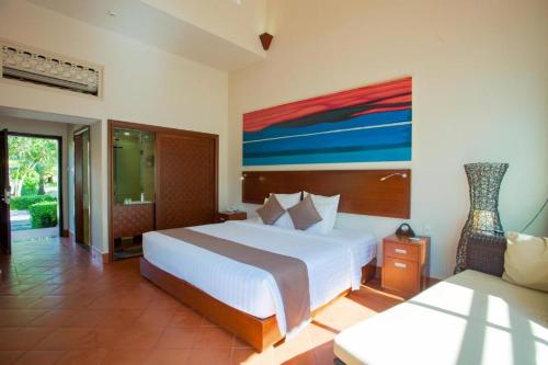 a bedroom with two beds and a painting on the wall at Mercury Phu Quoc Resort & Villas in Phu Quoc