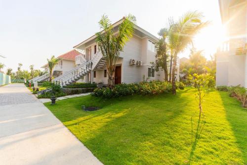 a house with a yard with palm trees at Mercury Phu Quoc Resort & Villas in Phu Quoc
