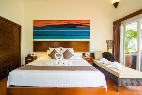 a bedroom with a bed and a painting on the wall at Mercury Phu Quoc Resort & Villas in Phu Quoc