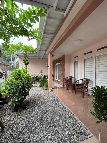 un patio interno con tavolo, sedie e piante di SYARIAH - Beautiful 3BR Home - 8 min from Centre by Sakura a Krawang