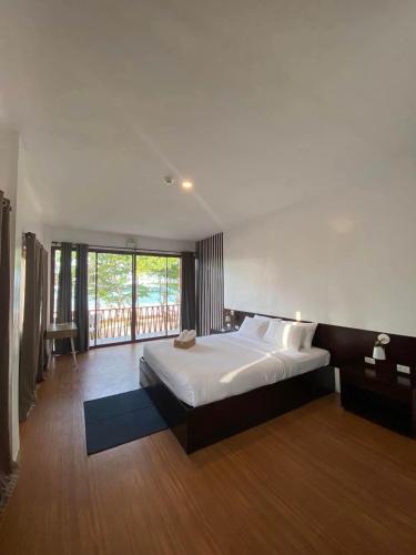 a bedroom with a large bed and a balcony at The Ananyana Beach Resort by SMS Hospitality in Panglao