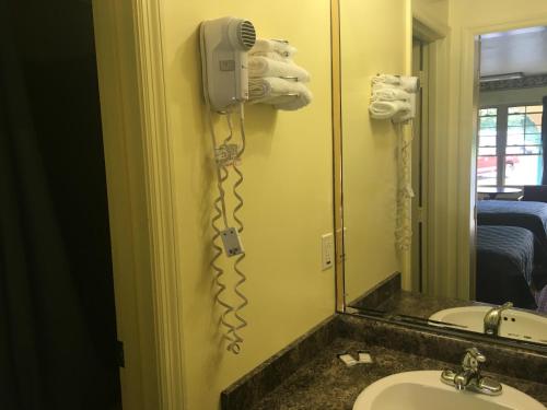 a bathroom with a phone on the wall next to a sink at Norwalk Inn in Norwalk