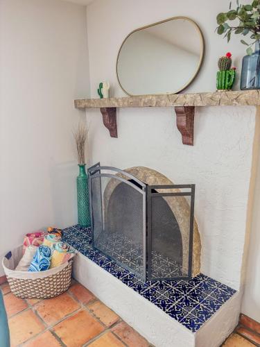 a stone fireplace with a mirror on the wall at Sun Dazed Tempe with Cali Soul Vibe in Tempe