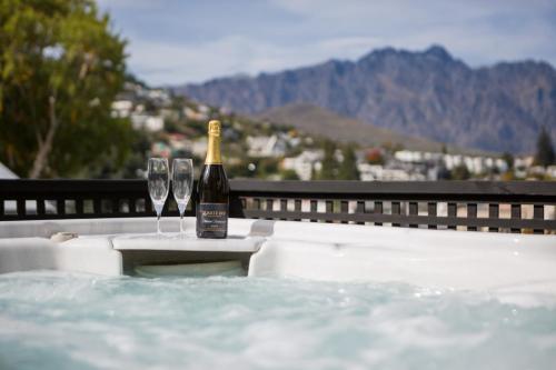 a bottle of champagne sitting on a table next to glasses at The Dairy Hotel Queenstown, A Naumi Chapter in Queenstown