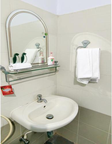 a bathroom with a sink and a mirror and towels at Rainbow Stays in Bengaluru