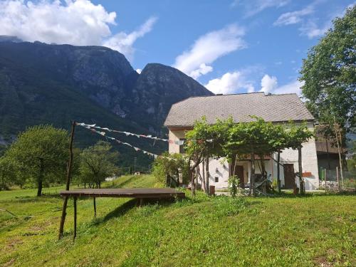a bench in front of a house with mountains in the background at Stara Hiša in Log Čezsoški