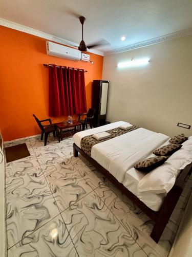 a bedroom with a bed and a table in a room at Le Oasis Auro'Raa in Puducherry