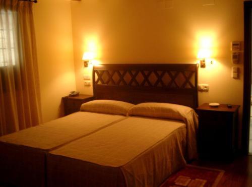 a bedroom with a bed and two lights on the wall at Finca Eslava in Antequera