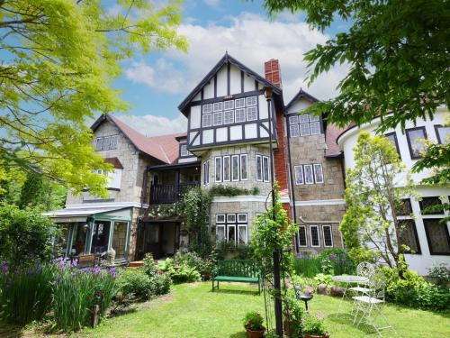 an old house with a garden in front of it at Petit Hotel & Restaurant Old Age in Hokuto