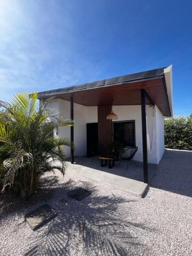 a white house with a roof with a patio at Apartamento 1, cerca de la playa, naturaleza y paz in Santa Cruz