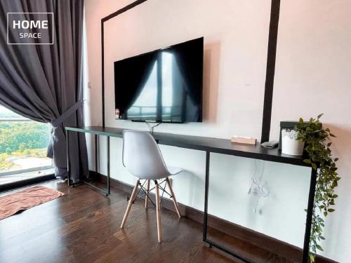 a desk with a tv and a chair in a room at Almas Puteri Harbour Nusajaya Suite room Exclusive Room 5 min to Legoaland by HomeSpace in Nusajaya