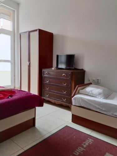 a bedroom with two beds and a dresser with a tv at Партерни студия без обособен балкон ул Т Светослав и ул българия in Pomorie