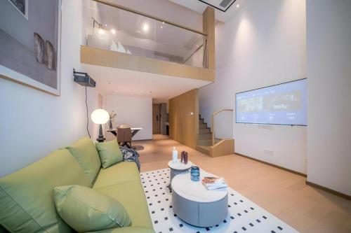 a living room with a couch and a projection screen at F-TOWN Fangtang Hotel (Shenzhen Longgang Tian'an Digital City Huanggekeng Subway Station) in Shenzhen