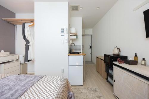 a large white kitchen with a bed in a room at Hotel-Like Simmons Bed Couple Disney Shinjuku in Tokyo