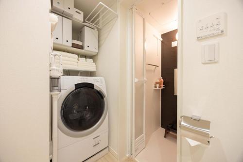 a washer and dryer in a small room at Hotel-Like Simmons Bed Couple Disney Shinjuku in Tokyo