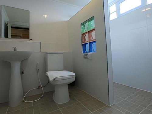 ein Badezimmer mit Toilette und Waschbecken und einem Fenster in der Unterkunft Muanmanee Boutique Hotel in Loei