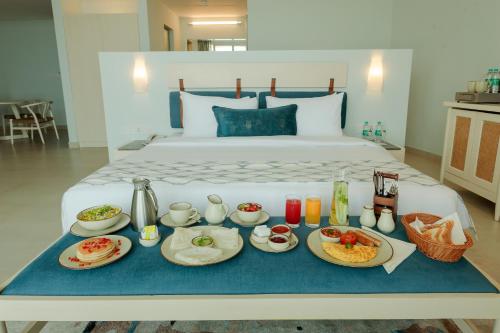 a tray of breakfast foods on a bed at Araqila Boutique Beach Resort near MOPA airport in Vengurla